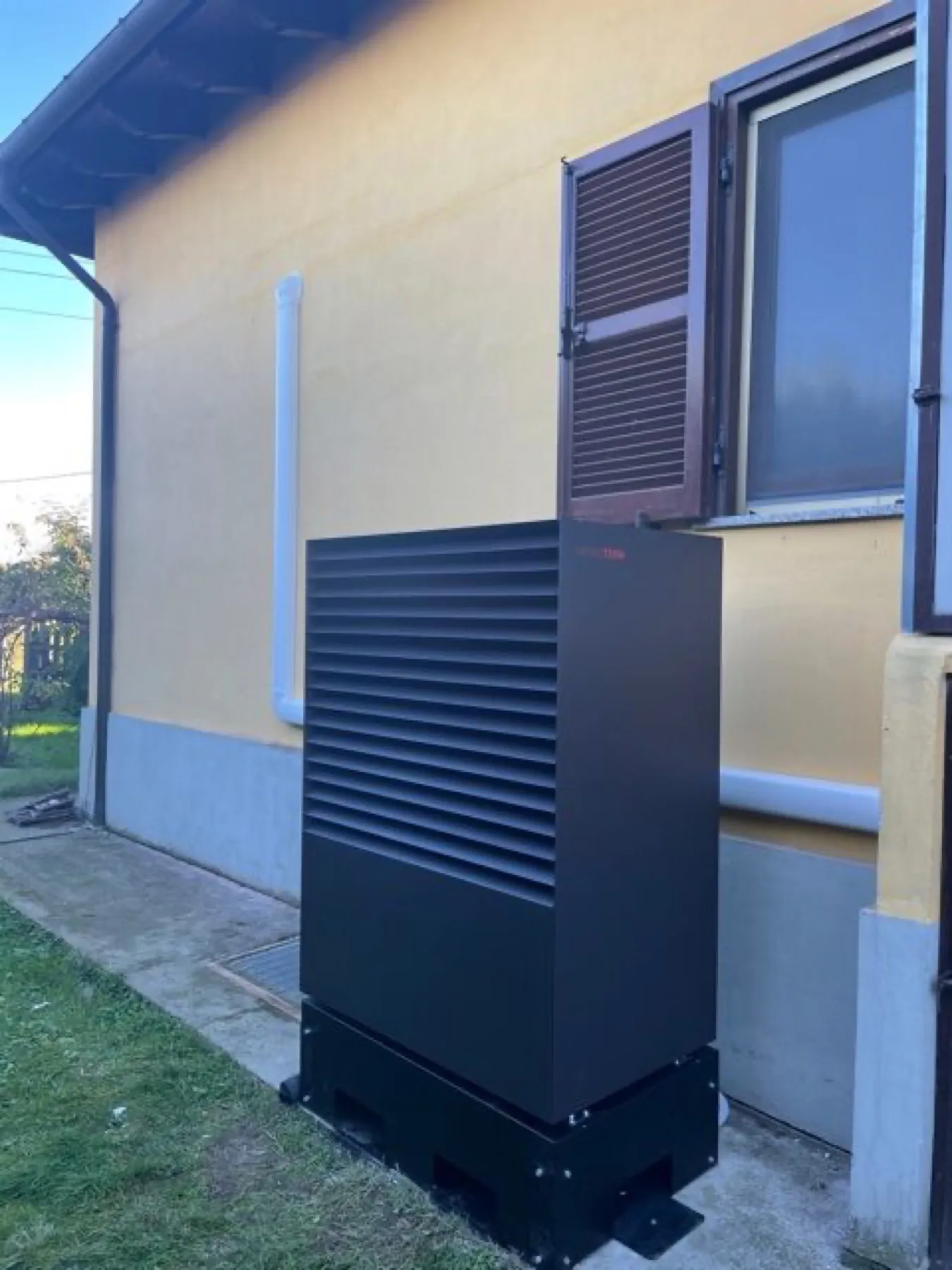 Unità esterna di una pompa di calore installata a bordo casa su staffe antivibranti
