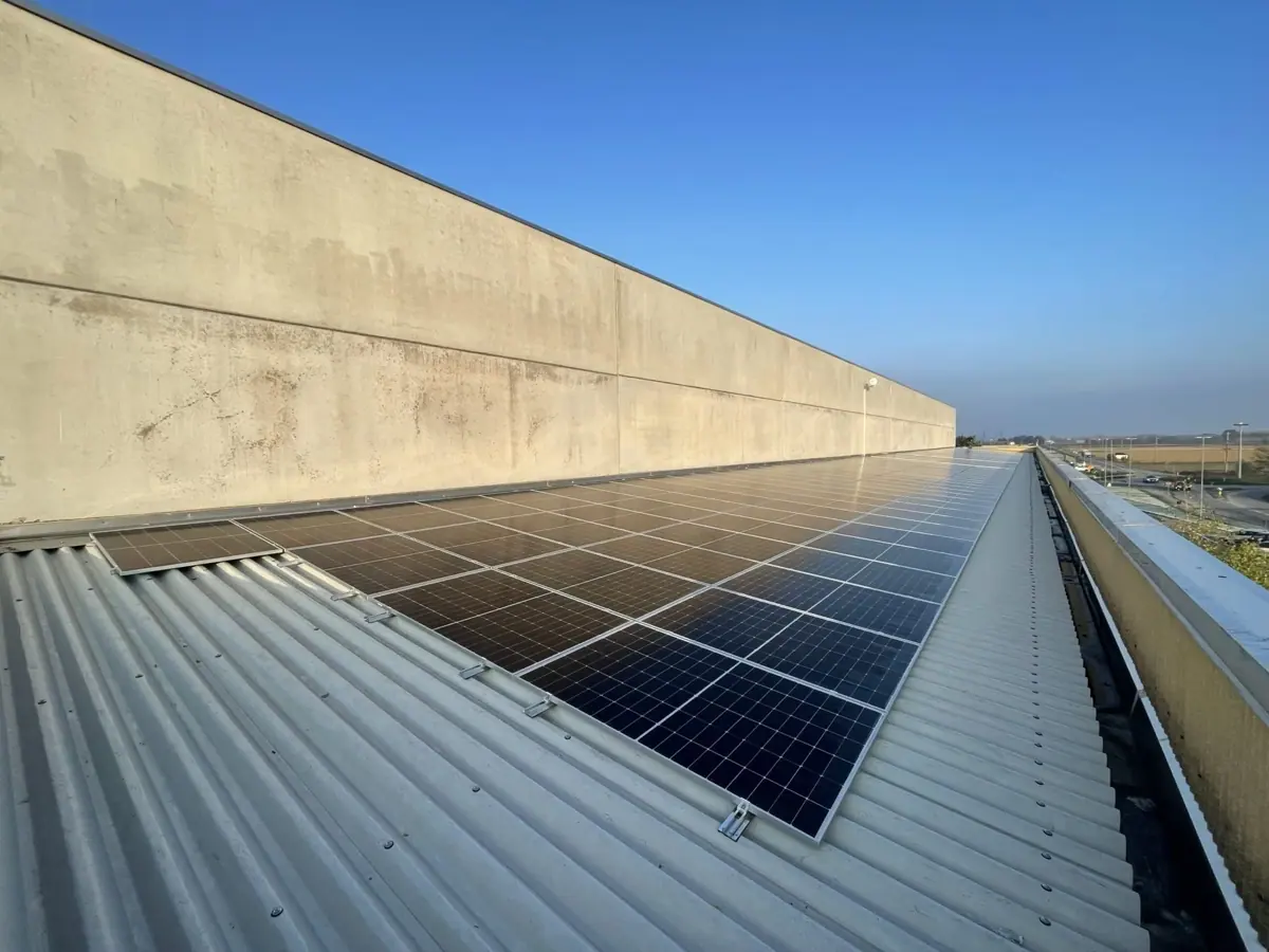 Stringhe di moduli fotovoltaici allineate su una copertura industriale